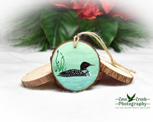 Common loon on a pond hand-painted on a wood slice.  The ornament is available for purchase at Cove Creek Photography.